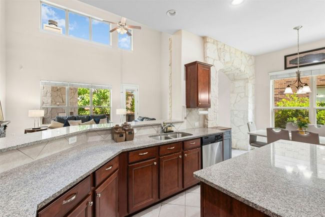 Gourmet kitchen with stainless steel appliances and large center island. | Image 4