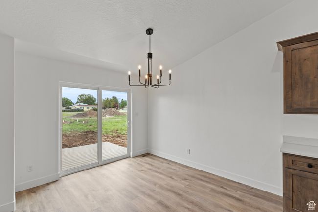Unfurnished dining area with a chandelier, light wood-type flooring, and baseboards | Image 8