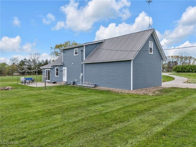 Rear view of property with a patio, metal roof, and a lawn | Image 39