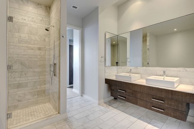Bathroom featuring a stall shower, marble finish floors, double vanity, and baseboards | Image 14