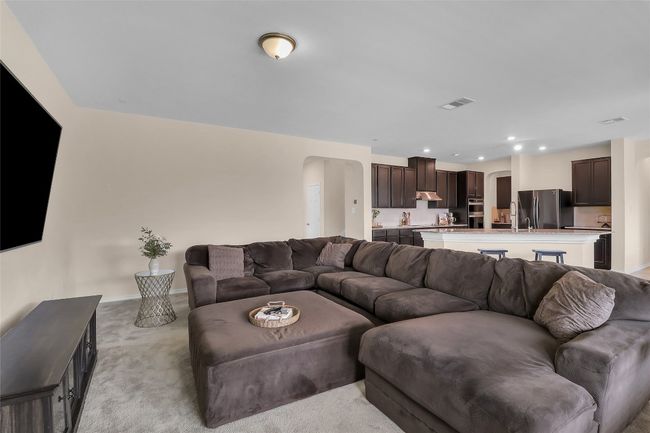 Living area featuring light carpet, arched walkways, baseboards, and recessed lighting | Image 5