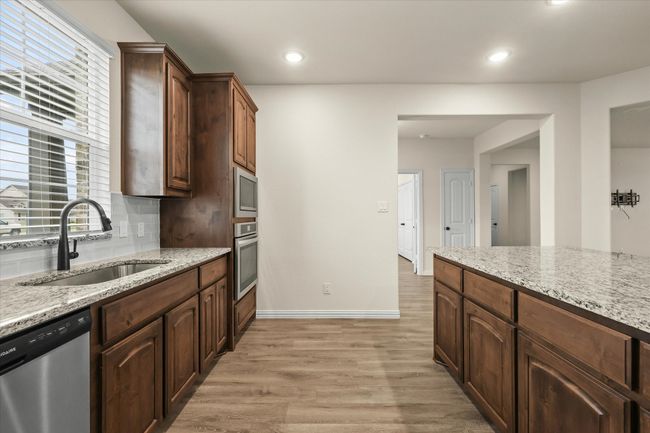 Kitchen featuring appliances with stainless steel finishes, light wood-type flooring, plenty of natural light, tasteful backsplash, and recessed lighting | Image 10