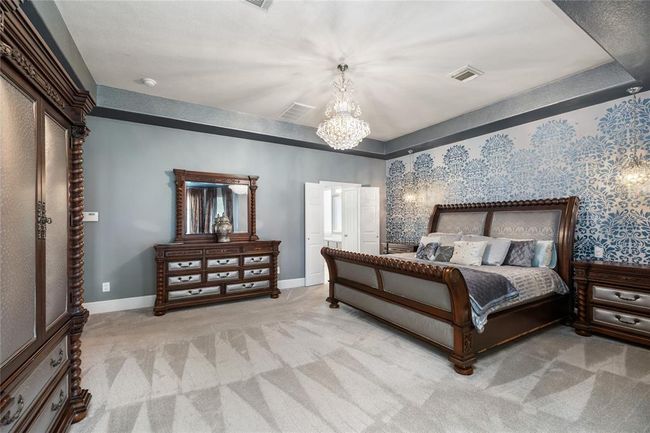 Wake up each morning in a space that feels more like a private getaway than a bedroom. Whether you're unwinding in the cozy sitting area with a book or enjoying the calm ambiance under the beautifully detailed tray ceiling, this suite offers room to relax, recharge, and truly feel at home. | Image 14