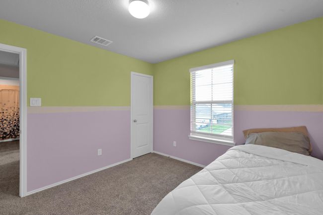 The third bedroom is located on the second floor and has a vibrant color palette. It is located toward the front left upper side of the home. | Image 25
