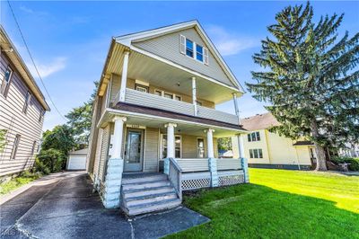 View of front of home with a front lawn, an outbuilding, covered porch, and a garage | Image 2