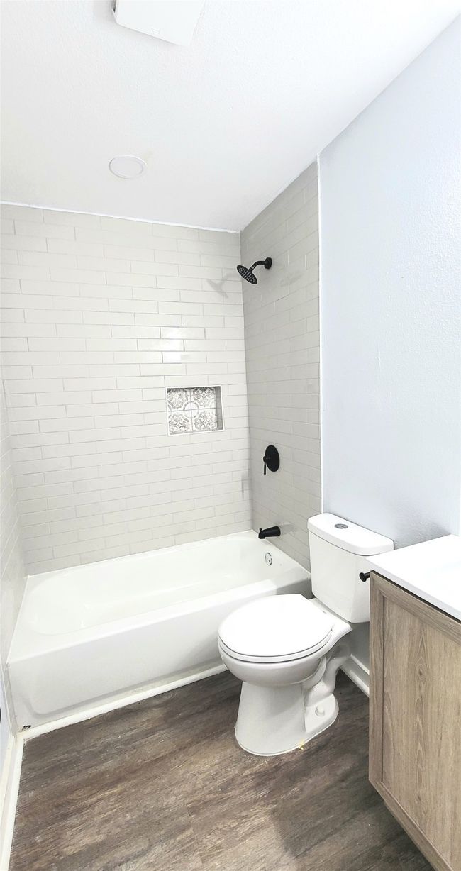Full bathroom with shower / bath combination, vanity, toilet, and wood finished floors | Image 10