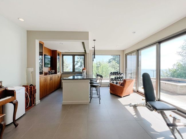 Kitchen with brown cabinetry, a kitchen bar, and light tile patterned floors | Image 23