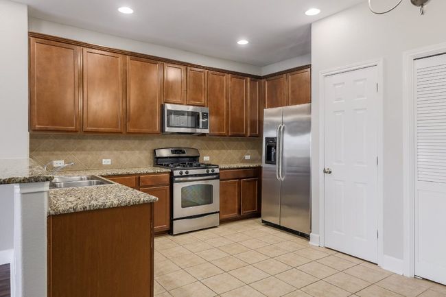 Kitchen with stainless steel appliances backsplash, tile floors, and recessed lighting | Image 9