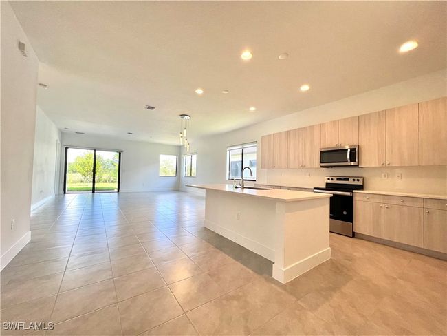 Kitchen with plenty of natural light, an island with sink, stainless steel appliances, and sink | Image 8