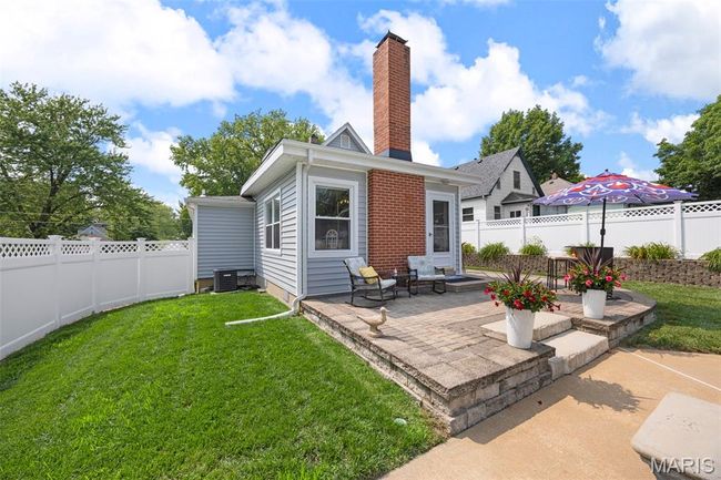 Rear view of property with a chimney, a patio area, and a fenced backyard | Image 43