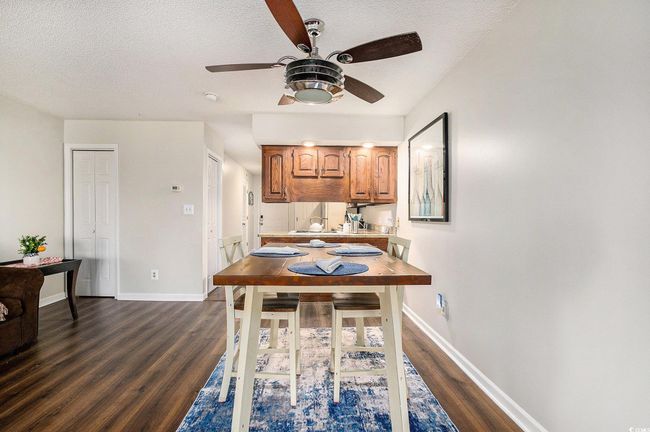 Dining space featuring a textured ceiling, a ceiling fan, and dark wood finished floors | Image 14