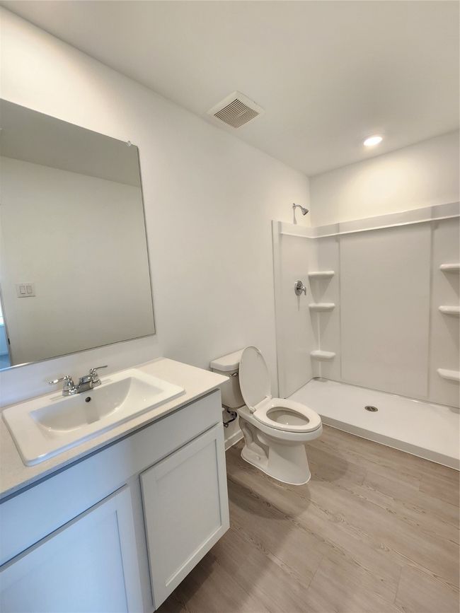 Bathroom featuring a stall shower, vanity, and wood finished floors | Image 10