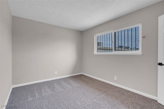 Carpeted empty room with a textured ceiling and baseboards | Image 30