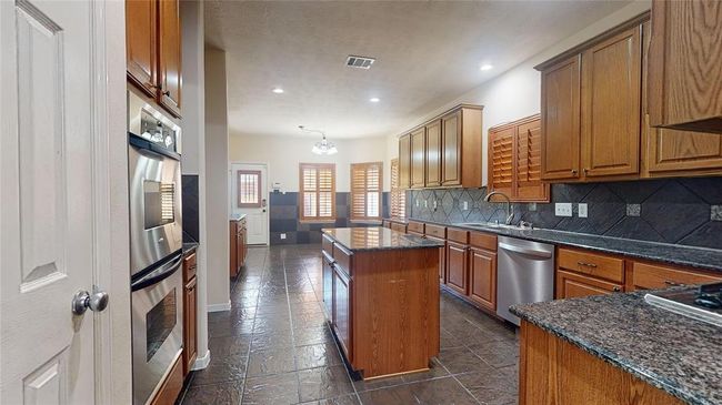 Spacious gourmet kitchen featuring a sleek center island. | Image 10