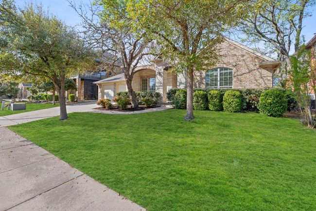 Ranch-style home with concrete driveway, a front yard, brick siding, and a garage | Image 35