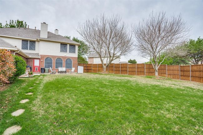 Fenced backyard with a patio area | Image 34