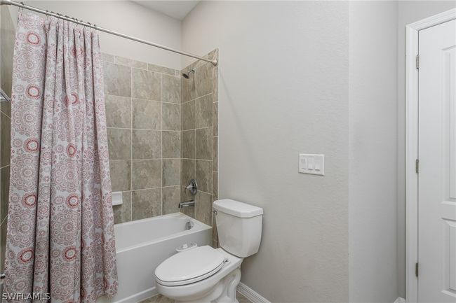 Bathroom featuring toilet and shower / tub combo | Image 15