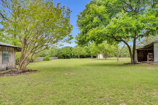 Looking to the back yard from the back porch, you see the Potting Shed on the left, the Shop on the right, and an additional storage shed in the back. | Image 30