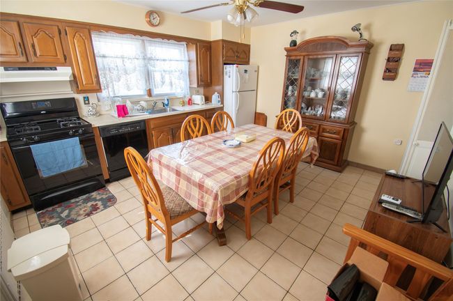 Dining space featuring light tile patterned floors, baseboards, and a ceiling fan | Image 8