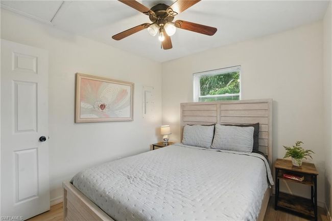Bedroom featuring light wood-type flooring, a ceiling fan, and attic access | Image 25