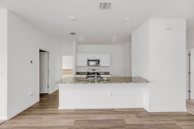 A convenient breakfast bar makes for a perfect spot for quick meals or casual conversations. | Image 11