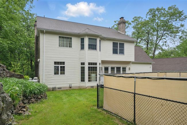 Rear view of property with a chimney, a yard, and crawl space | Image 47