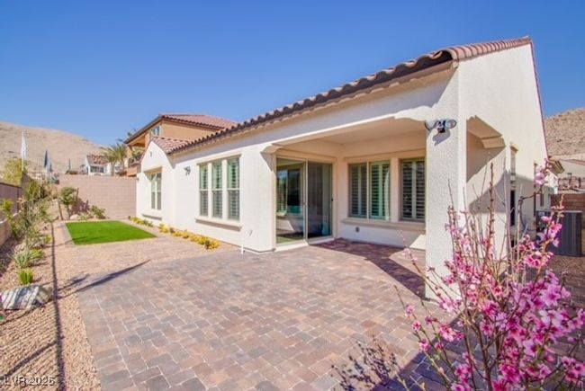 Back of property featuring stucco siding, a fenced backyard, a patio, and a tile roof | Image 13