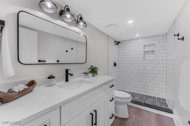 Full bath featuring vanity, tiled shower, recessed lighting, and wood finished floors | Image 27