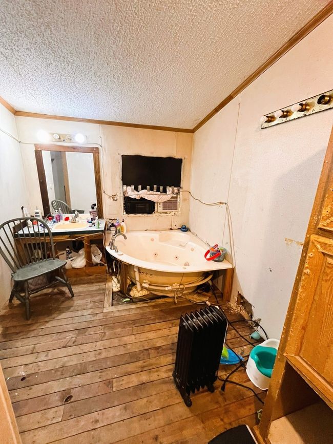 Bathroom featuring ornamental molding, a textured ceiling, a whirlpool tub, and hardwood / wood-style floors | Image 15