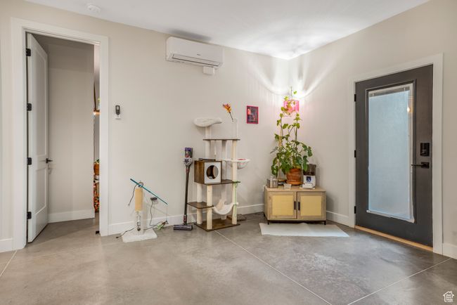 Interior space with concrete flooring, baseboards, and a wall unit AC | Image 40