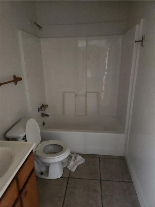 Full bathroom featuring vanity, tile patterned floors, shower / tub combination, and toilet | Image 4