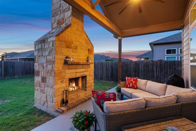 Fenced backyard featuring an outdoor living space with a fireplace | Image 30