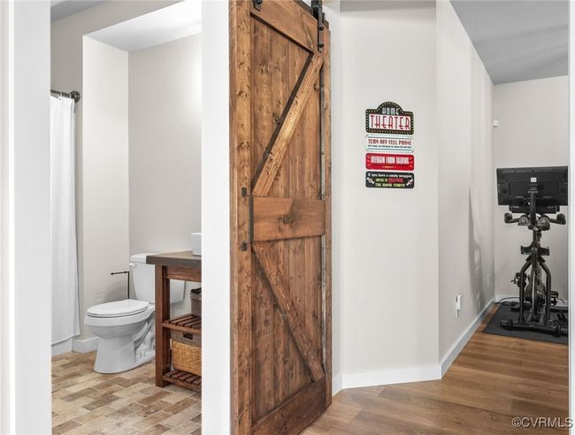 Full basement bathroom with rustic vanity, barn door and brick floor | Image 38