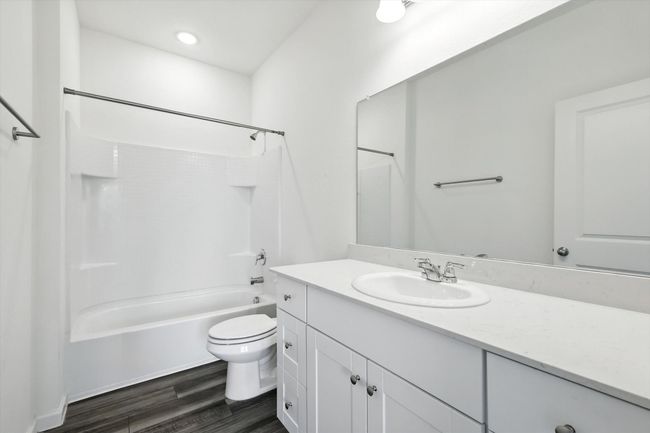 Bathroom featuring vanity, shower / washtub combination, and wood finished floors | Image 11