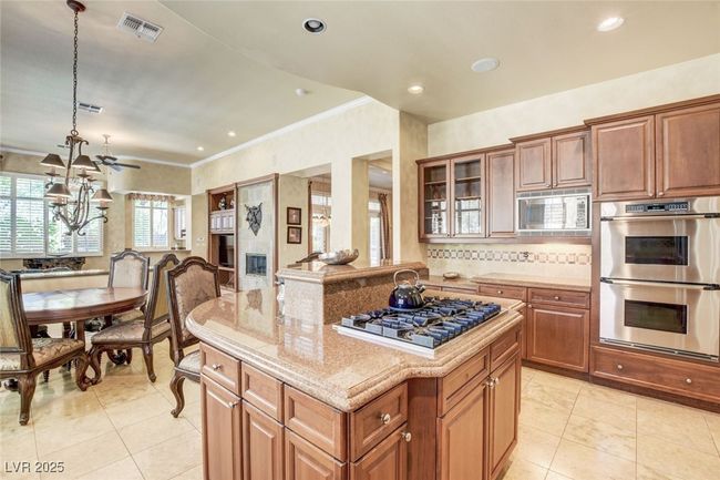 Kitchen with light stone counters, visible vents, stainless steel appliances, and brown cabinetry | Image 18