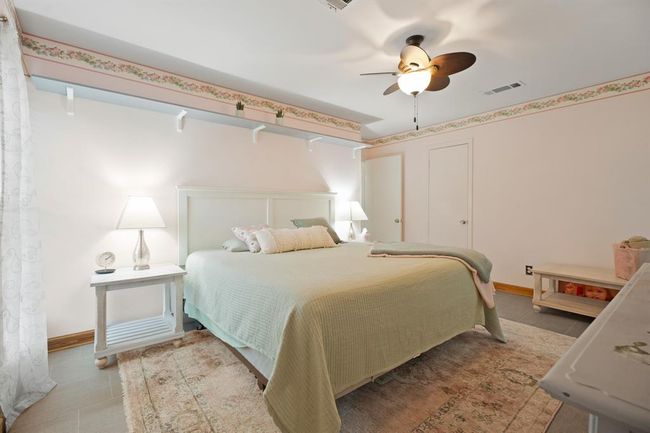 Secondary bedroom with walk-in closet and ceiling fan. | Image 26