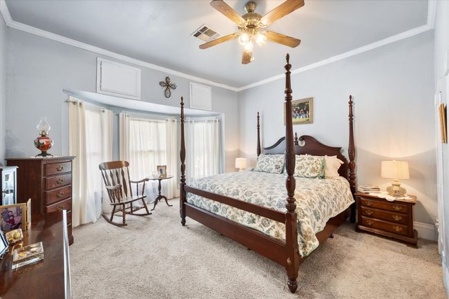 Bedroom featuring carpet flooring, crown molding, and a ceiling fan | Image 23