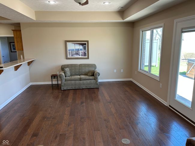 living area with baseboards, dark wood-style flooring, and a tray ceiling | Image 8