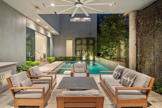 View of the outdoor pool surrounded by the house back/side facades and privacy wall - quiet and elegant with its arrangement of outdoor furniture. An oversized fan and mosquito misting system make the outdoor area more enjoyable during hotter/humid weather patterns. | Image 40