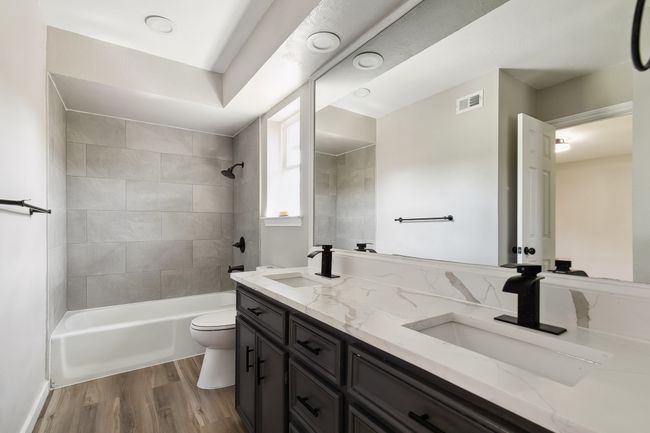 Full bath featuring wood finished floors, visible vents, toilet, and a sink | Image 28
