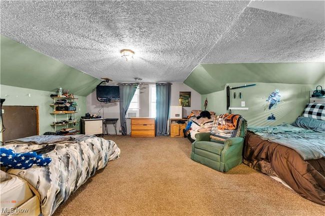 Bedroom with light carpet, lofted ceiling, and a textured ceiling | Image 25