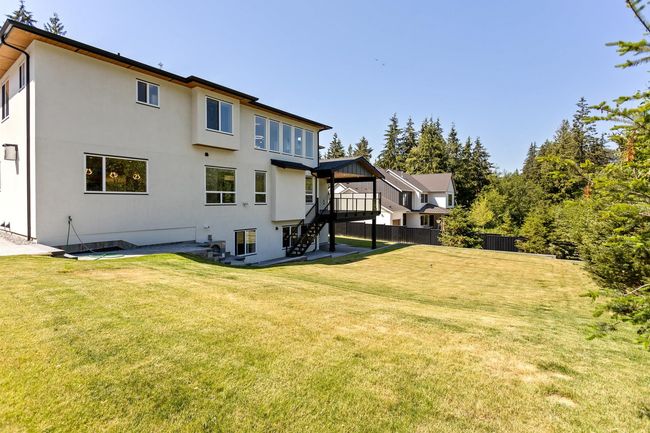 Back of property featuring stairway, a lawn, stucco siding, and fence | Image 4