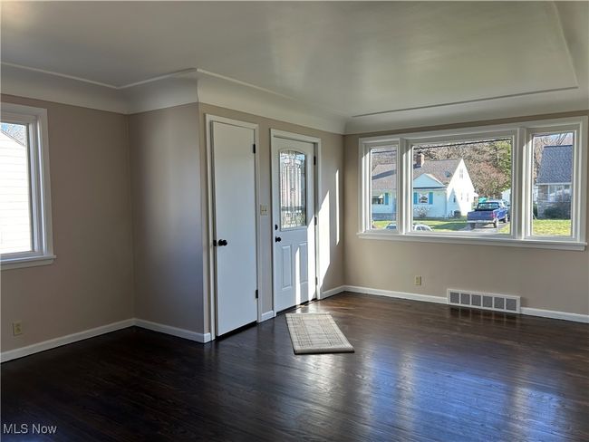 Front Door, coat closet and dark wood floors. | Image 13