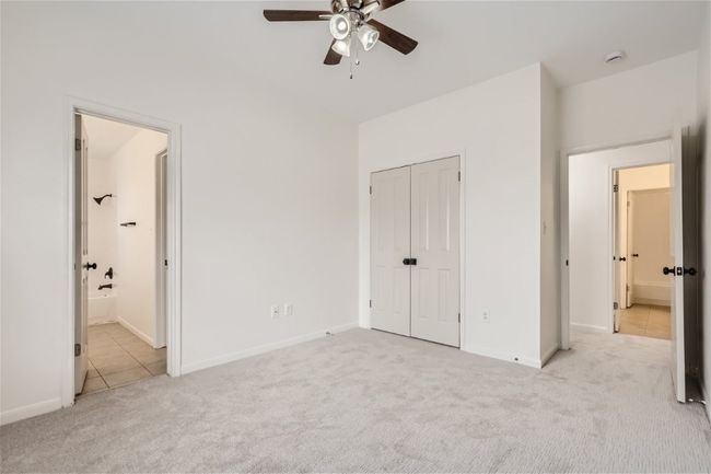 Unfurnished bedroom with light carpet, light tile patterned floors, baseboards, a closet, and ensuite bathroom | Image 26