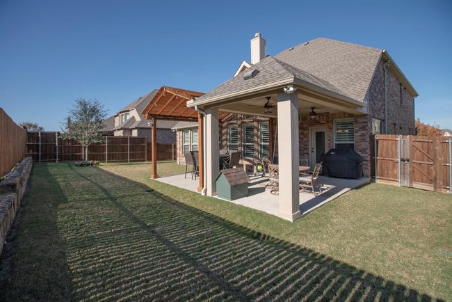 Fenced backyard featuring a ceiling fan, a gate, and a patio area | Image 36