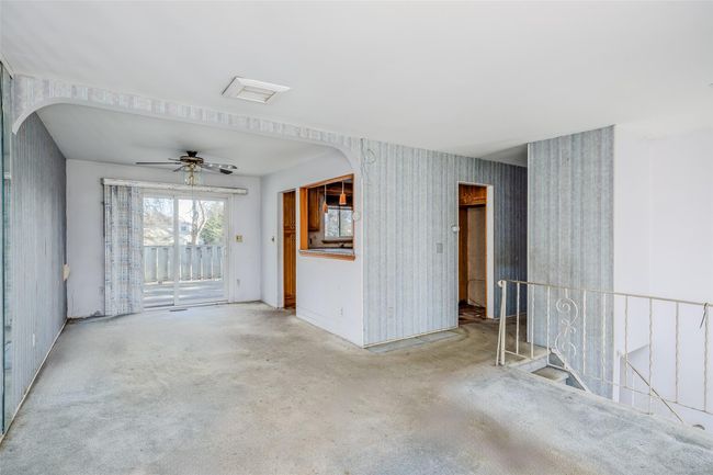 Unfurnished room featuring wallpapered walls, visible vents, arched walkways, and a ceiling fan | Image 8