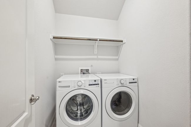 Washroom with full size washing machine and clothes dryer. There is also a storage shelfs in the corner. | Image 34