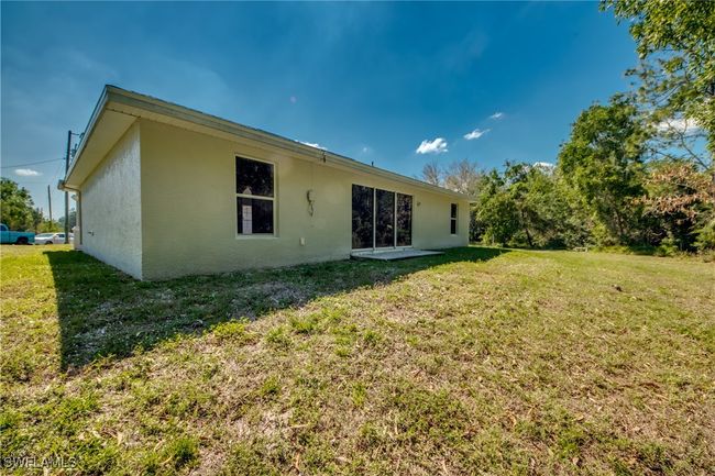 Rear view of house with stucco siding and a yard | Image 48