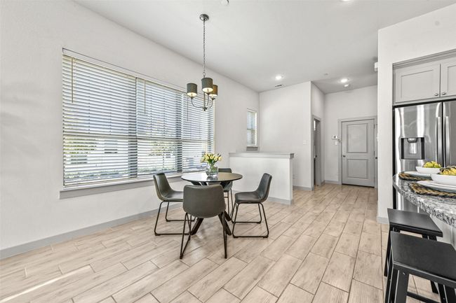 Dining space with a notable chandelier and light hardwood / wood-style floors | Image 13