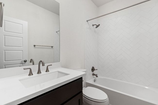 Bathroom with toilet, vanity, and washtub / shower combination | Image 25